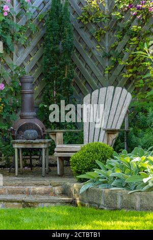 Jardin privé et paysagé (design contemporain, plantes grimpantes et border, clôture, siège de mobilier de jardin et chiminea) - Yorkshire, Angleterre, Royaume-Uni. Banque D'Images
