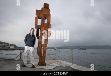 Sir Antony Gormley pose une photo à côté de son œuvre « look II » sur West Hoe Pier à Plymouth, qui fait partie de l'exposition « Making IT », avec de nouvelles œuvres d'Antony Gormley, Kehinde Wiley et Lenore Antunes, au musée Box de Plymouth, Devon. Banque D'Images