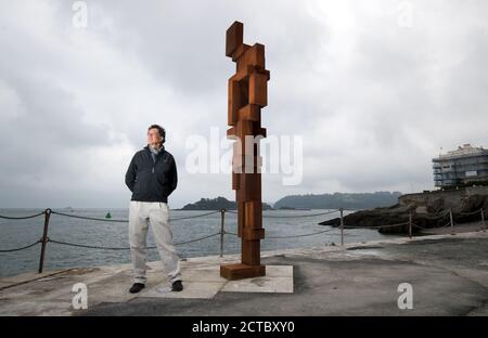 Sir Antony Gormley pose une photo à côté de son œuvre « look II » sur West Hoe Pier à Plymouth, qui fait partie de l'exposition « Making IT », avec de nouvelles œuvres d'Antony Gormley, Kehinde Wiley et Lenore Antunes, au musée Box de Plymouth, Devon. Banque D'Images