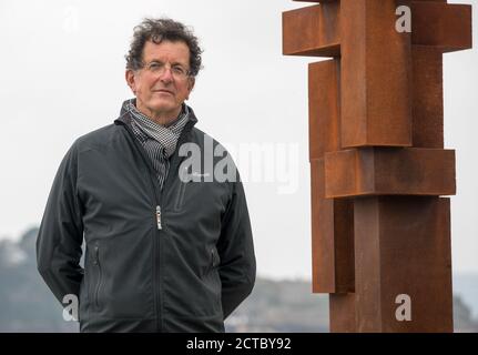 Sir Antony Gormley pose une photo à côté de son œuvre « look II » sur West Hoe Pier à Plymouth, qui fait partie de l'exposition « Making IT », avec de nouvelles œuvres d'Antony Gormley, Kehinde Wiley et Lenore Antunes, au musée Box de Plymouth, Devon. Banque D'Images