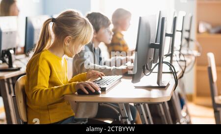 École élémentaire informatique salle de classe : divers Groupe de petits élèves intelligents utilisant des ordinateurs personnels, apprendre l'informatique, Internet Banque D'Images