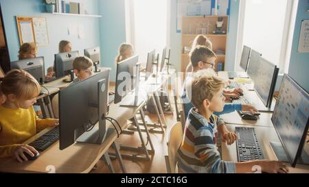 École élémentaire informatique salle de classe : divers Groupe de petits élèves intelligents utilisant des ordinateurs personnels, apprendre l'informatique, Internet Banque D'Images