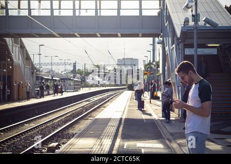 Londres, Royaume-Uni - 16 avril 2019 - passagers en attente de trains à la plate-forme de la gare de West Hampstead Banque D'Images