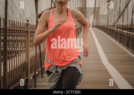 Femme pratiquant le jogging sur le pont de Brooklyn Banque D'Images