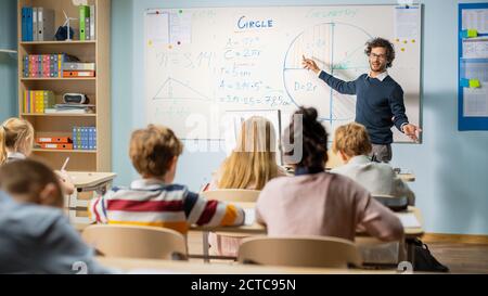 Un professeur enthousiaste explique les leçons et pose des questions dans une salle de classe pleine d'enfants brillants et divers. Dans le Groupe d'école élémentaire de Smart Banque D'Images