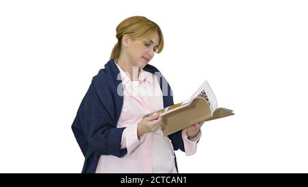 Femme blonde enceinte lisant le magazine sur fond blanc. Banque D'Images