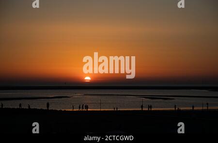 Silhouette de personnes sur la plage regardant le coucher du soleil sur l'île de Borkum, Frise, Basse-Saxe, Allemagne, Europe. Banque D'Images