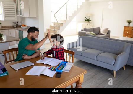 Père et fils élevés se fiant les uns les autres à la maison Banque D'Images