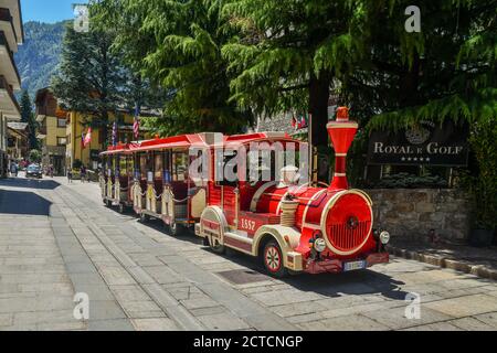 Un petit train touristique garé en face du Grand Hotel Royal e Golf 5 étoiles au centre de la ville de montagne en été, Courmayeur, Aoste, Italie Banque D'Images