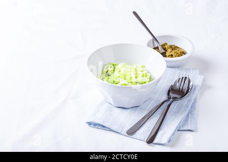 Nuddles de Zucchini sains avec pesto sur fond blanc. Placer pour le texte. Banque D'Images