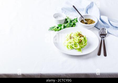 Nuddles de Zucchini sains avec pesto sur fond blanc. Placer pour le texte. Banque D'Images