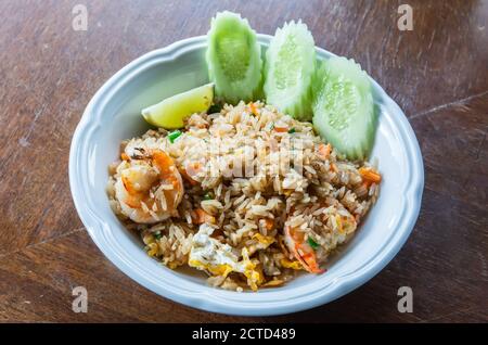 Riz frit de style thaïlandais aux œufs et crevettes, servi avec du citron et du concombre. Banque D'Images