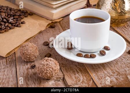 café frais préparé dans une cafetière (traditionnelle turque) boisson du matin dans une tasse blanche à côté des boules de chocolat Banque D'Images