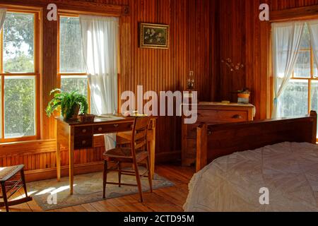 Chambre, meubles anciens, vieux bureau, petite commode, lit, murs en bois, époque pionnière de la Floride, Guptill House, 1901, fenêtres ensoleillées, Spani historique Banque D'Images