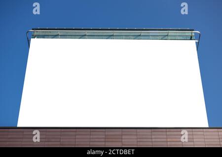 Maquette. Grand panneau blanc vierge sur la façade d'un immeuble moderne en hauteur de la ville Banque D'Images