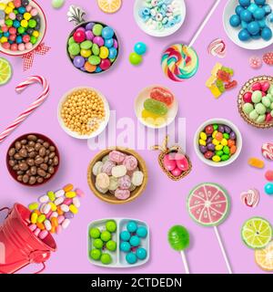 Bonbons, chocolats et sucettes sur fond rose. Toile de fond, bannière o fond avec bonbons. Vue de dessus des bonbons colorés. Banque D'Images