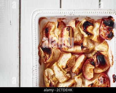 Tranches de pomme cuites à la cannelle dans un plat de cuisson. Banque D'Images