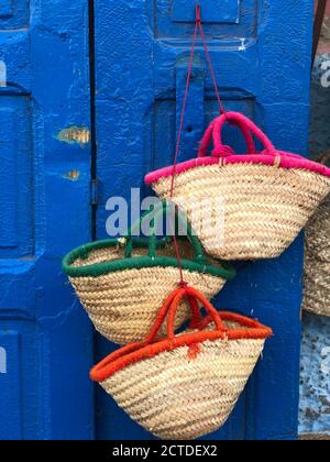 Marocains, sacs de paille sur fond bleu à Médina d'Essaouira. Banque D'Images