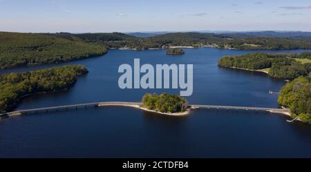 Photo aérienne du lac de Vassivière avec la petite île forestière au milieu du pont vers l'île de Vassivière, haute-Vienne, Limousin, France Banque D'Images