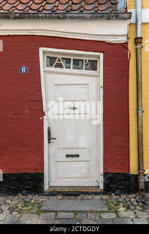 Tonder, Danemark, le 31 mai 2020 : une porte inclinée, à flancs de lop, dans une maison en ruine, dans une ancienne ruelle pavée Banque D'Images