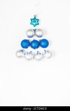 Composition de Noël ou du nouvel an 2021. Magnifique sapin de Noël fait de décorations bleues et argentées sur fond blanc et espace de copie. Carte de vœux Banque D'Images