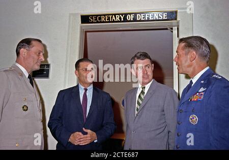 Le secrétaire à la Défense Robert S. McNamara tient une conférence spontanée en dehors de son bureau au Pentagone. De gauche à droite : Général Earle G. Wheeler, USA, président, Comité des chefs d'état-major (JCS) ; McNamara, vice-ministre de la Défense Cyrus R. Vance ; et le Lieutenant-général David A. Burchinal, USAF, directeur de l'état-major interarmées, de JCS. Banque D'Images