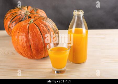 Jus de citrouille frais dans une tasse de verre et citrouilles d'orange. Concept alimentaire sain et savoureux. Récolte d'automne. Concept de jus de citrouille Banque D'Images