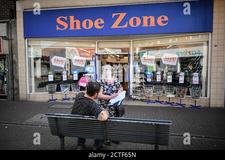 La face changeante de la rue haute. Une femme porte une visière intégrale lorsqu'elle mène un sondage dans la zone commerciale relativement vide d'East Street, à Bedminster, à Bristol, où de nombreux magasins et entreprises sont fermés, environ six mois après la soirée du 23 mars, lorsque le Premier ministre Boris Johnson a annoncé des restrictions à l'échelle nationale. Banque D'Images