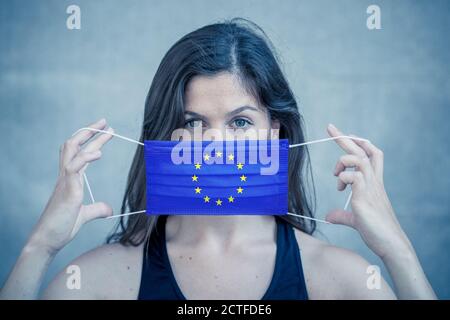 Épidémie de coronavirus en Europe et crise sanitaire mondiale. Femme portant un masque facial drapeau de l'Union européenne contre l'infection, 2019 nouveau coronavirus. Con Banque D'Images