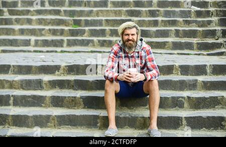 Repos. Retirez le café. Dose de caféine. Filtrer le café. Le lot de préparation est versé sur le café. Homme avec la barbe qui boit du café. Homme barbu boisson fond urbain. Hipster se détendre dans les escaliers. Banque D'Images