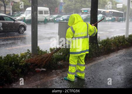 Les citoyens vont au travail en marchant, en prenant des moteurs ou en conduisant pendant les heures de pointe, quand les fortes pluies sont causées par le typhon Hagupit, le quatrième typhon de la y Banque D'Images