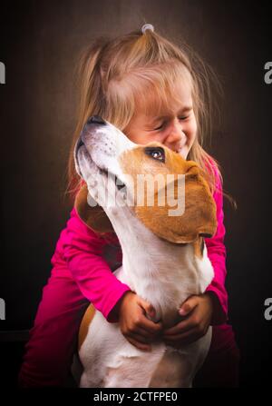 2 yeras vieux enfant embrassant meilleur ami chien. Bonne enfance avec Beagle. Banque D'Images