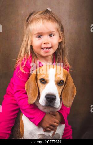 2 yeras vieux enfant embrassant meilleur ami chien. Bonne enfance avec Beagle. Banque D'Images