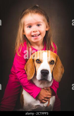 2 yeras vieux enfant embrassant meilleur ami chien. Bonne enfance avec Beagle. Banque D'Images