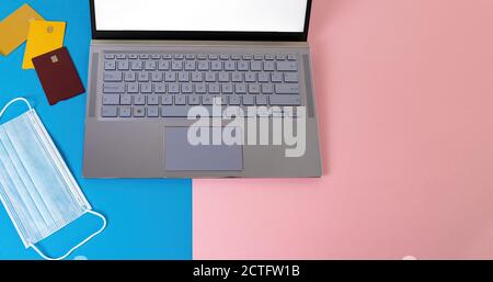 Prise de vue en grand angle d'un ordinateur portable à proximité de cartes et d'un masque facial Banque D'Images