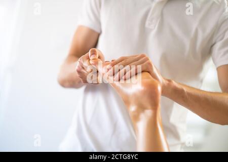 Masseur professionnel faisant un massage thérapeutique. Femme profitant d'un massage dans sa maison. Jeune femme se relaxant massage corporel. Banque D'Images