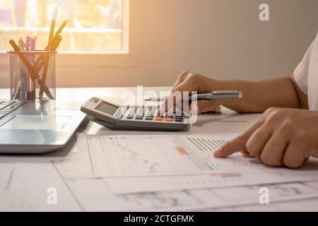 Gros plan d'hommes d'affaires ou de comptables tenant un stylo et appuyant sur la calculatrice pour calculer des informations d'affaires, des documents comptables, des affaires Banque D'Images