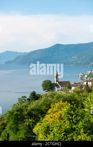 Vue panoramique sur l'église et le lac alpin majeur avec la montagne à Ronco sopra Ascona, Suisse. Banque D'Images