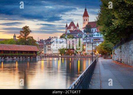Thun, Suisse. Image de paysage urbain de la belle ville de Thun avec le reflet de la ville dans la rivière Aare au coucher du soleil. Banque D'Images