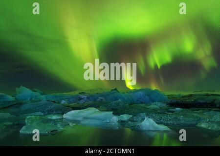 Aurora borealis au-dessus de la mer. Lagon du glacier de Jokulsarlon, Islande. Feux verts du nord. Ciel étoilé avec lumières polaires. Nuit paysage d'hiver Banque D'Images