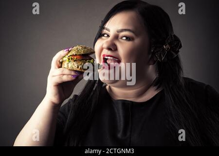 portrait femme graisse manger hamburger Banque D'Images
