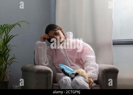 Femme médecin en costume de protection prenant repos après avoir assisté à Covid patients Banque D'Images