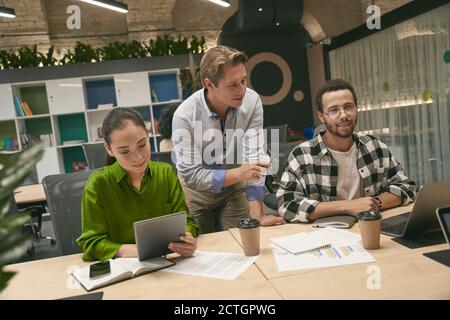 Brainstorming. Des gens d'affaires multiraciaux qui travaillent ensemble dans l'espace de bureau ou de travail de collègues moderne, trois collègues différents discutent de nouveau projet, communiquent et partagent des idées nouvelles Banque D'Images