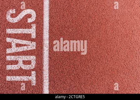 Ligne peinte en blanc sur une piste de terre en tartan dans un terrain d'athlétisme et de sport. . Photo de haute qualité Banque D'Images