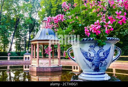 Belvédère en bois et vase avec fleurs décorées d'aigle à double tête dans le jardin d'été de Saint-Pétersbourg, Russie Banque D'Images