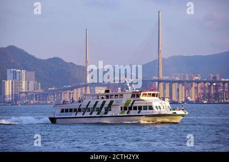 Ferry de banlieue à grande vitesse (Discovery Bay 19) dans le port de Victoria, à Hong Kong, en toile de fond du pont Stonecutters Banque D'Images