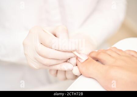 Manucure classique aux orteils de mariage rose sur fond blanc. Concept de soins spa Banque D'Images