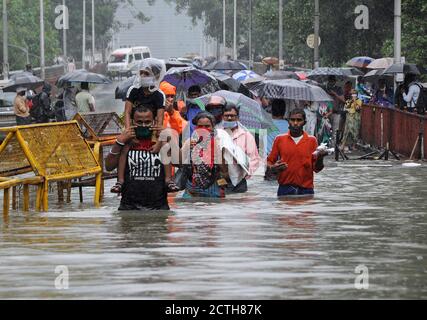 Mumbai, Inde. 23 septembre 2020. Un homme portant un enfant sur son épaule se wade à travers la taille de l'eau profonde. De fortes pluies ont heurté la ville, ce qui a entraîné l'engorgement et les gens ont eu de la difficulté à traverser la rue inondée. De fortes pluies ont écrasé la ville, ce qui a entraîné l'engorgement et les gens ont du mal à traverser les eaux inondées. Crédit : SOPA Images Limited/Alamy Live News Banque D'Images