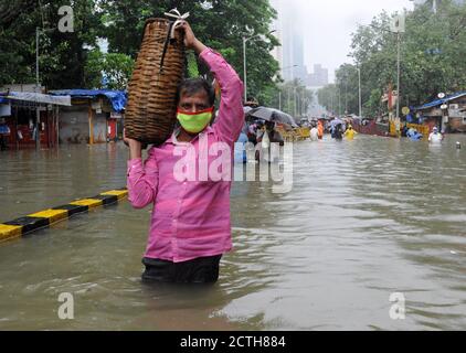 Mumbai, Inde. 23 septembre 2020. Un homme portant un panier se déporte à travers la taille en eau profonde. De fortes pluies ont heurté la ville, ce qui a entraîné l'engorgement et les gens ont eu de la difficulté à traverser la rue inondée. De fortes pluies ont écrasé la ville, ce qui a entraîné l'engorgement et les gens ont du mal à traverser les eaux inondées. Crédit : SOPA Images Limited/Alamy Live News Banque D'Images