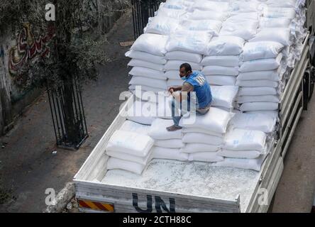 Gaza, Palestine. 22 septembre 2020. Un travailleur palestinien est vu assis derrière un camion de l'ONU (Nations Unies) transportant des sacs de nourriture pour distribution dans des maisons de réfugiés dans le camp de Jabalia.travailleurs palestiniens avec l'Office de secours et de travaux des Nations Unies pour les réfugiés palestiniens (UNRWA), Fournir des rations d'aide alimentaire aux foyers du camp de Jabalia, dans le nord de la bande de Gaza, plutôt que de les distribuer dans un centre des Nations Unies le 23 septembre 2020, en raison de la pandémie COVID-19. Crédit : SOPA Images Limited/Alamy Live News Banque D'Images